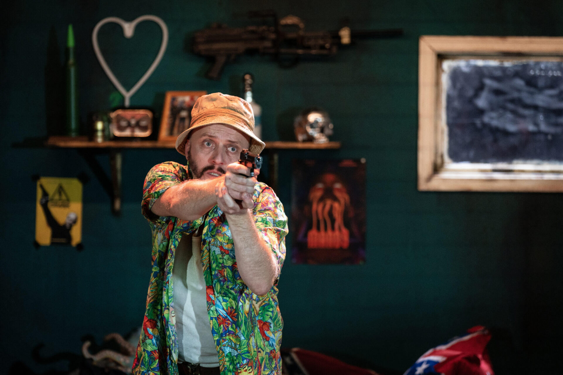 En mann peker mot oss med en pistol