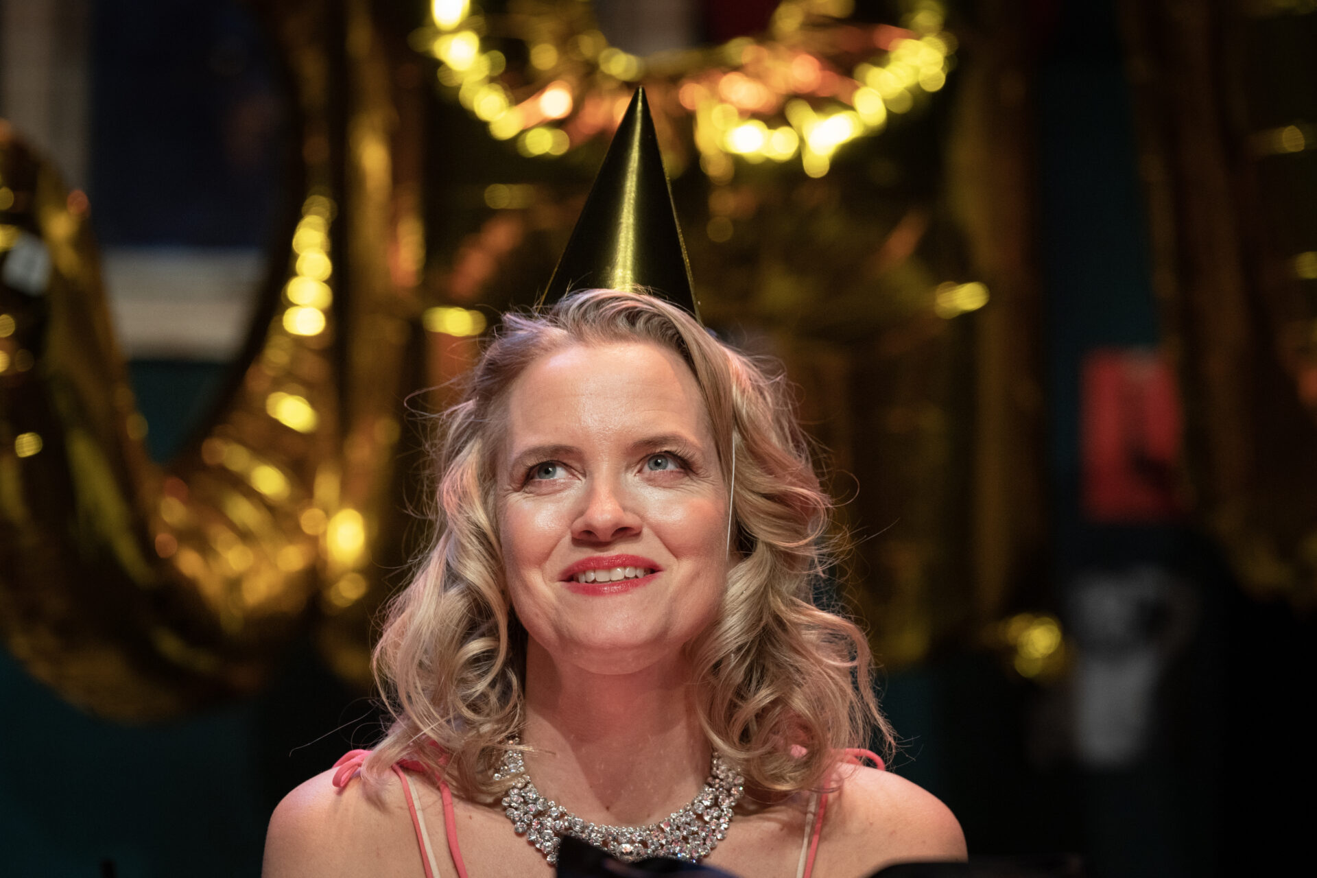 En kvinne med en gull papirhatt på hodet