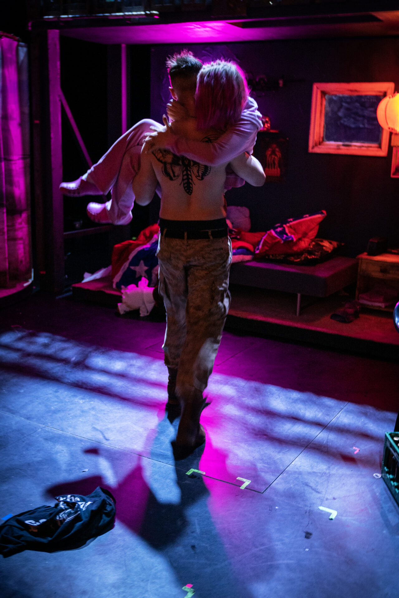 En mann bærer en kvinne mot en seng