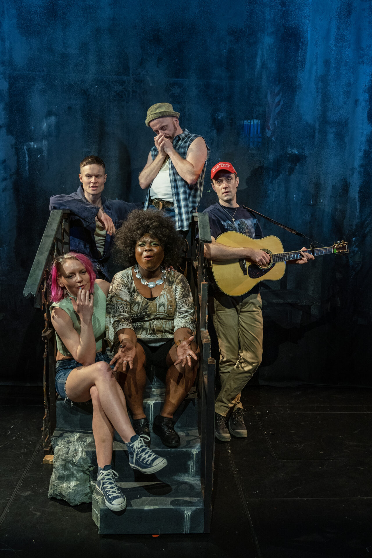 En gruppe på tre menn og to kvinner sitter i en trapp