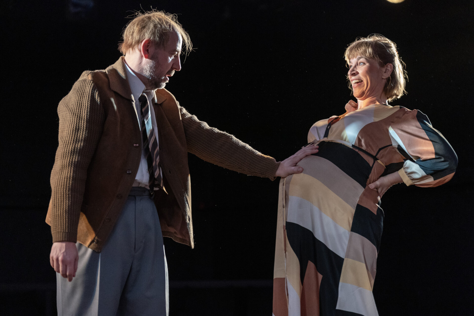 En mann kjenner på en kvinnes gravide mange