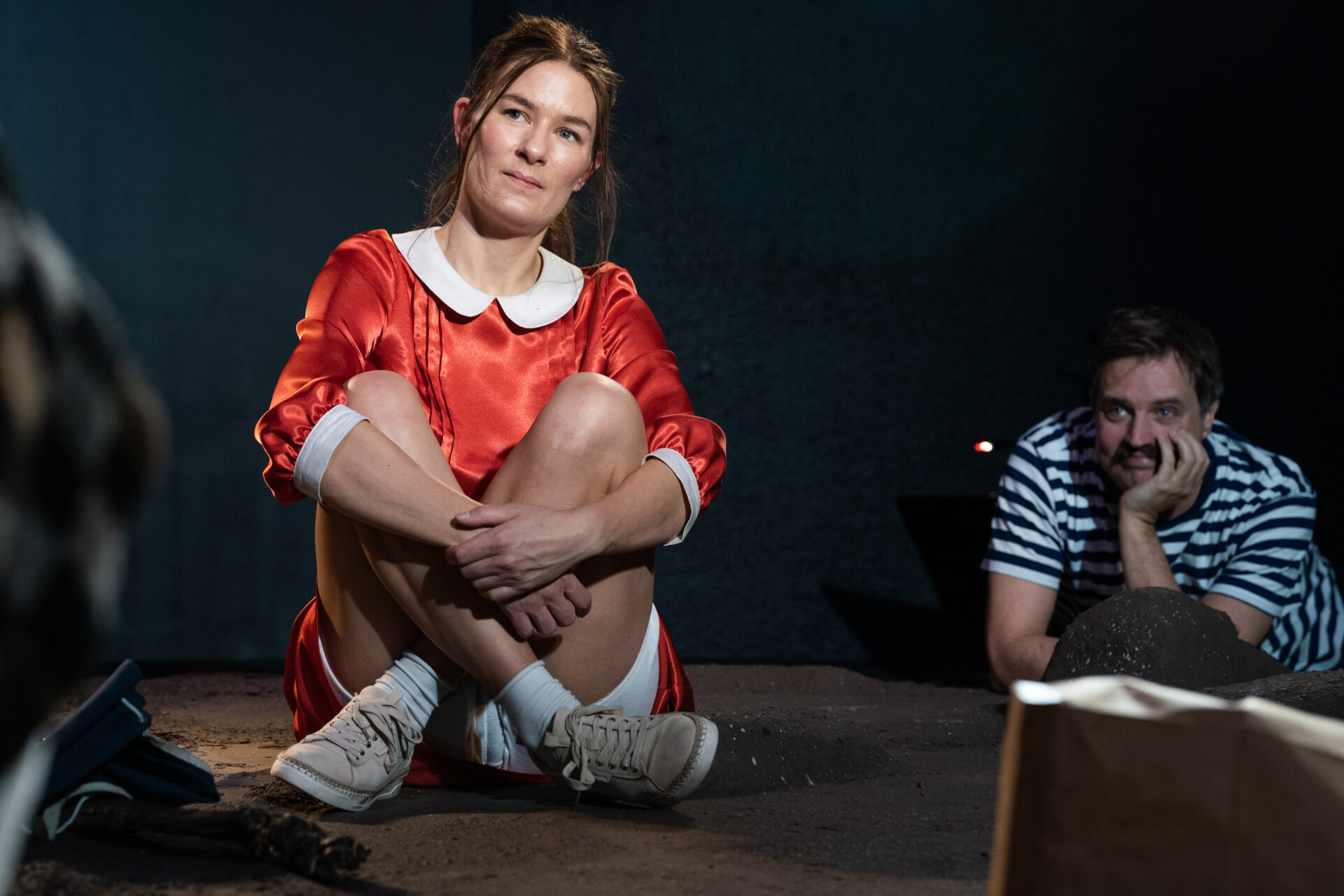 En ung kvinne stirrer ut i luften og blir betraktet av en mann