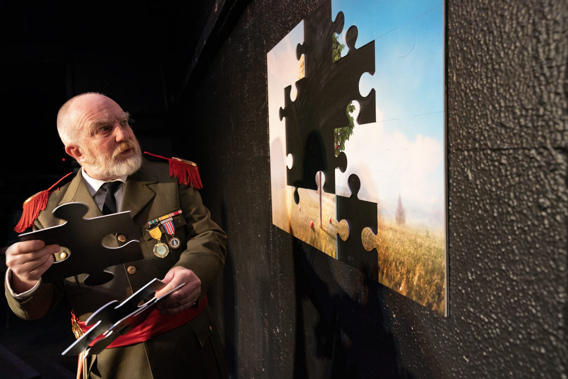 En gammel oberst legger puslespill på veggen