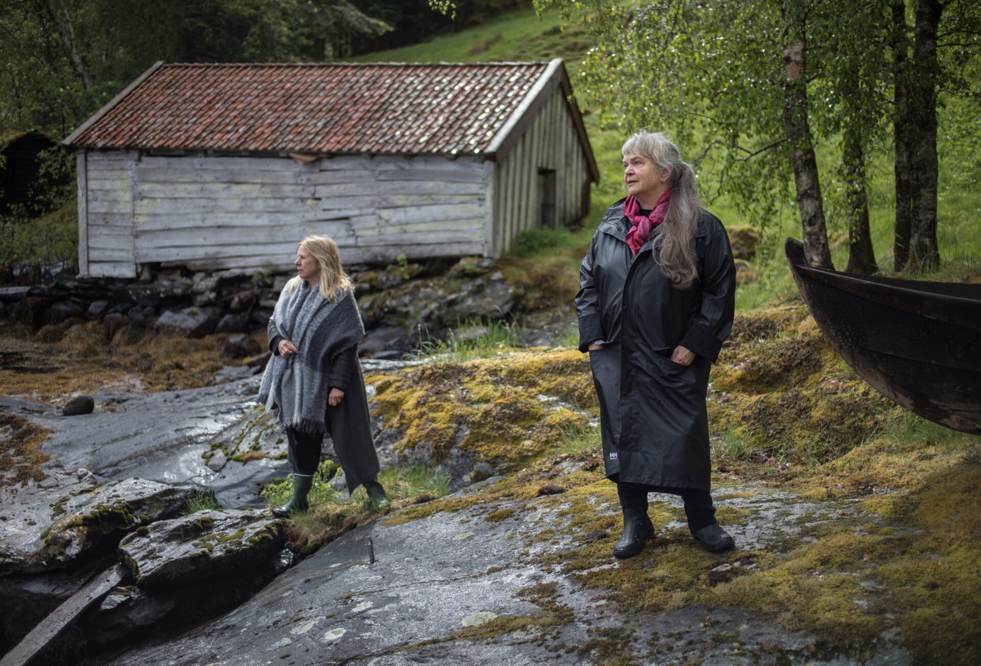 Anne Marit Jacobsen og Sinikka Langeland står på en skrent og ser ut mot sjøen