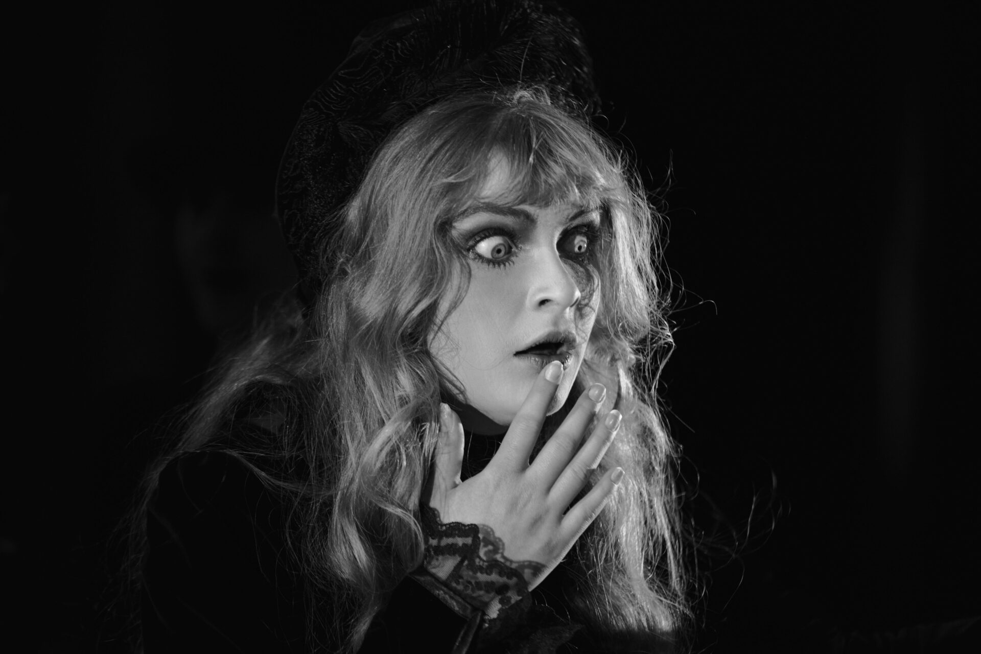 En kvinne med store øyne ser skrekkslagent på noe utenfor bilde