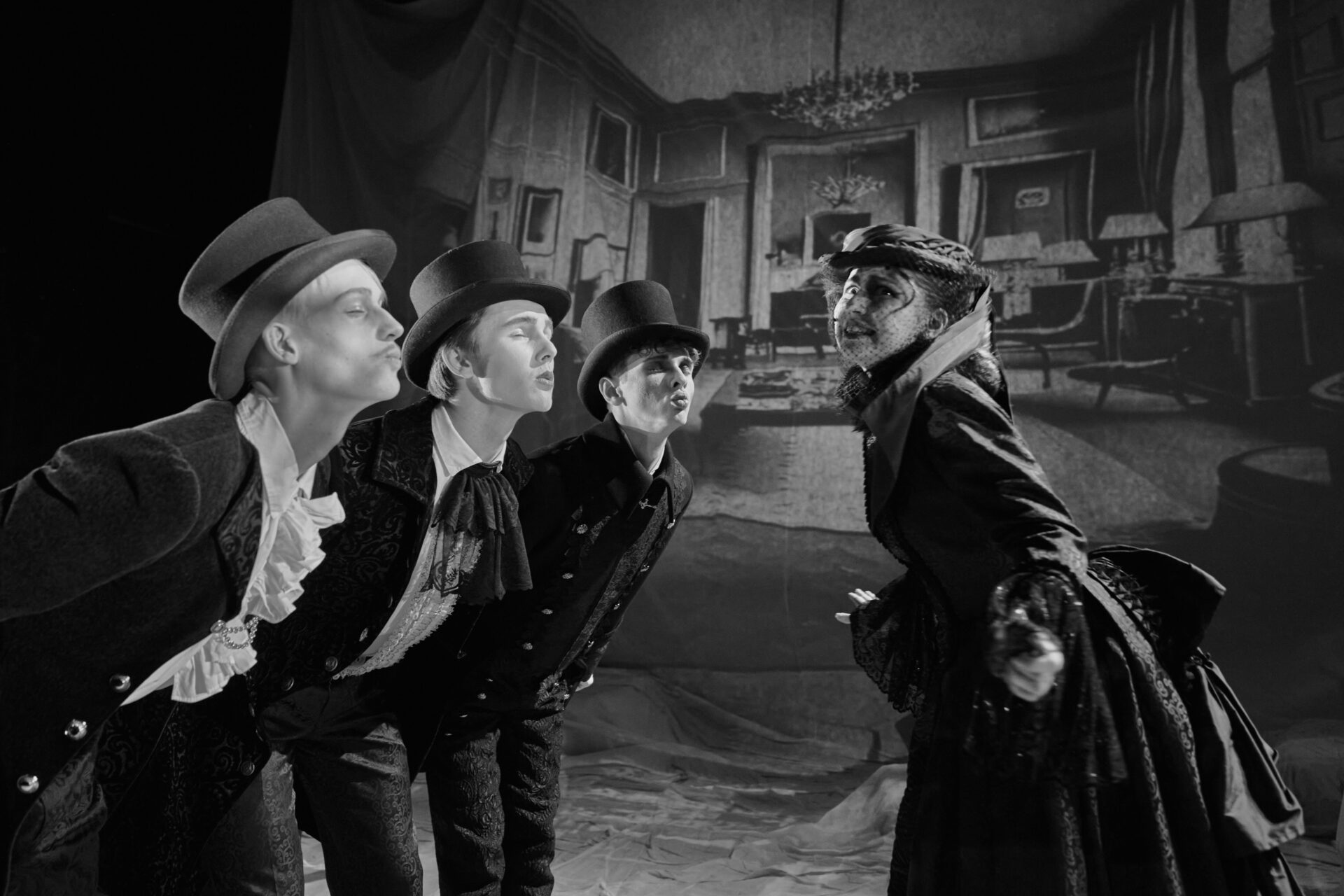 Tre menn står fremoverlent med trutmunn og ønsker et kyss av en kvinne