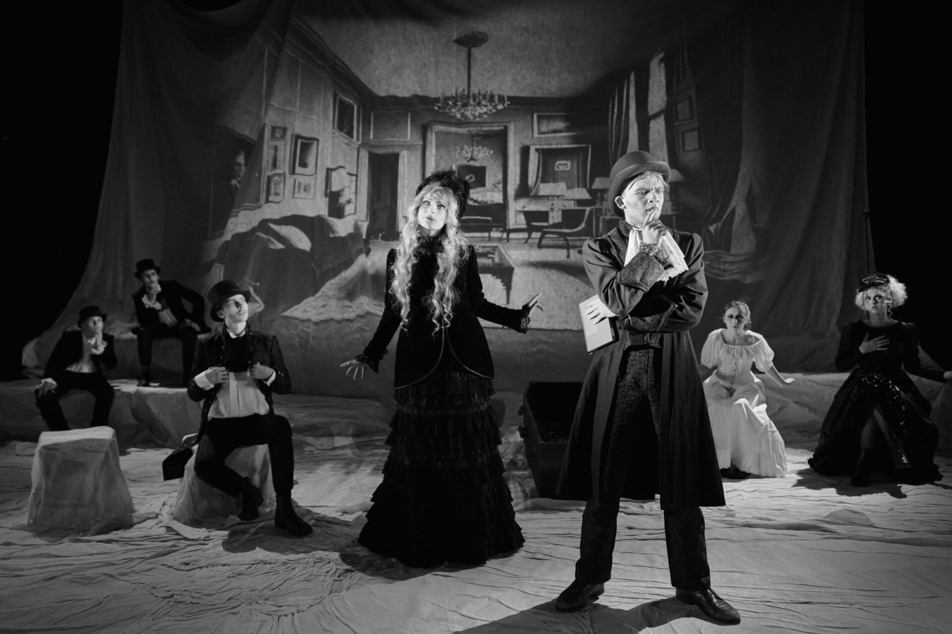 En mann står og tenker hardt i en befolket stue