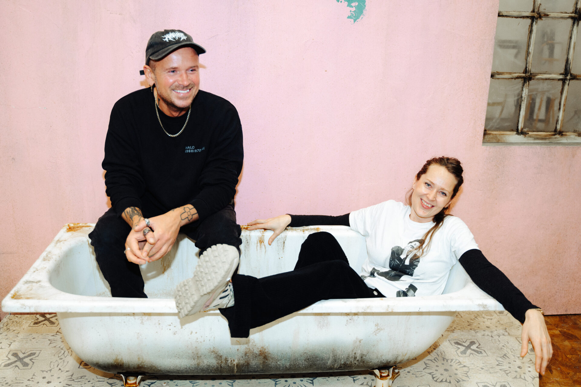 En mann og en kvinne sitter påkledd i et badekar, som er en del av scenografien itl En sporvogn til begjær