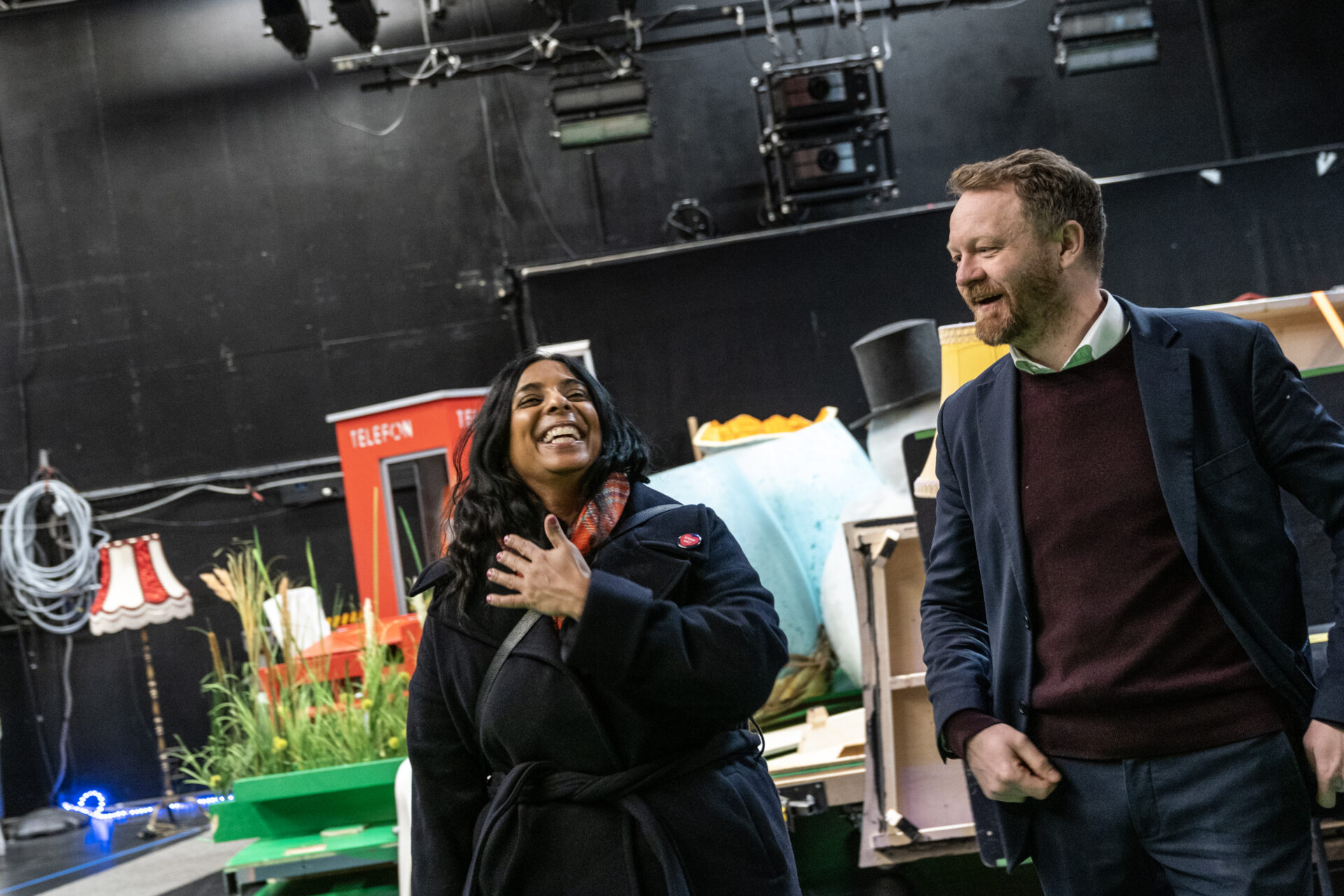 En kvinne ler, mens en mann ser på henne.