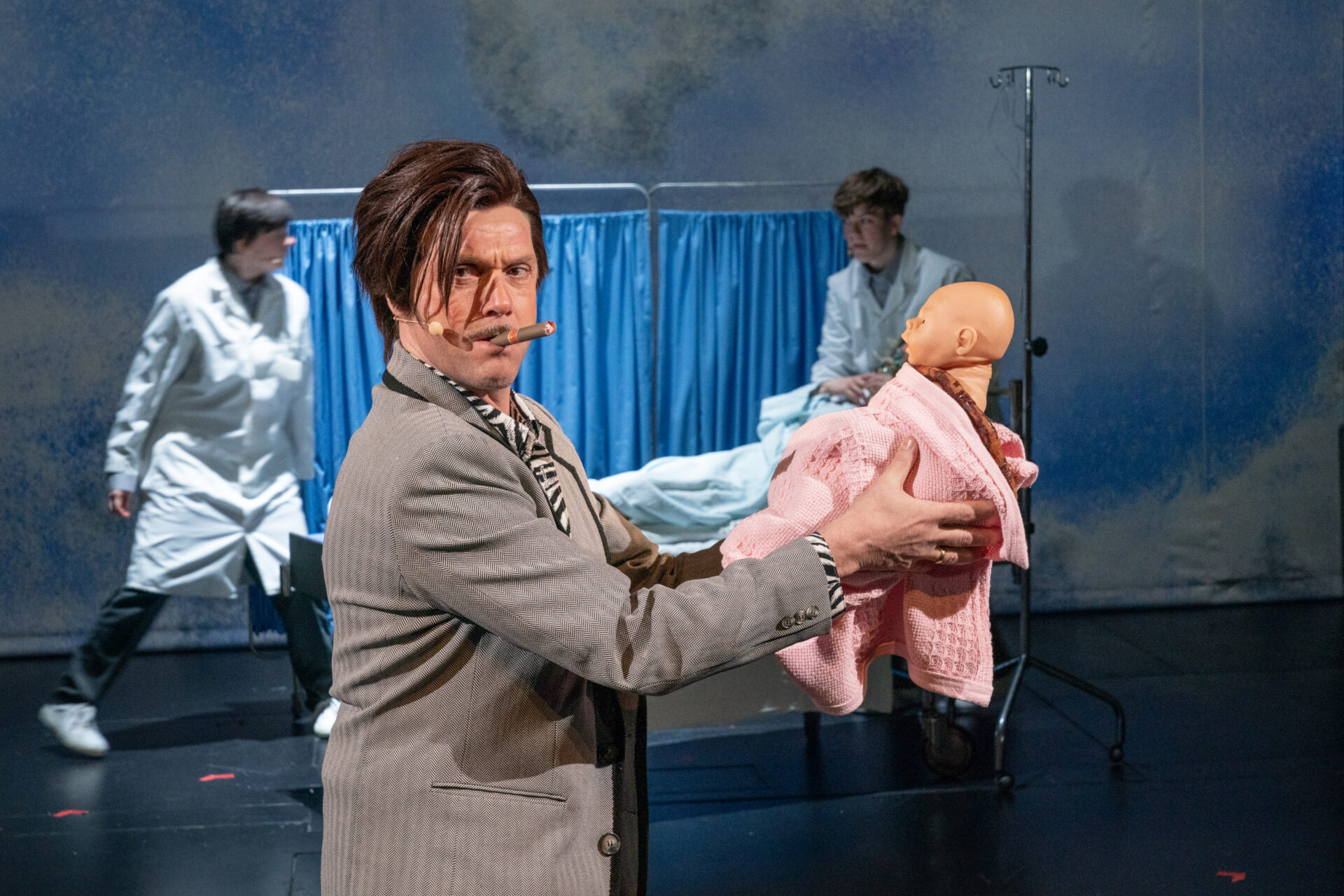 En mann med sigar holder sitt nyfødte barn