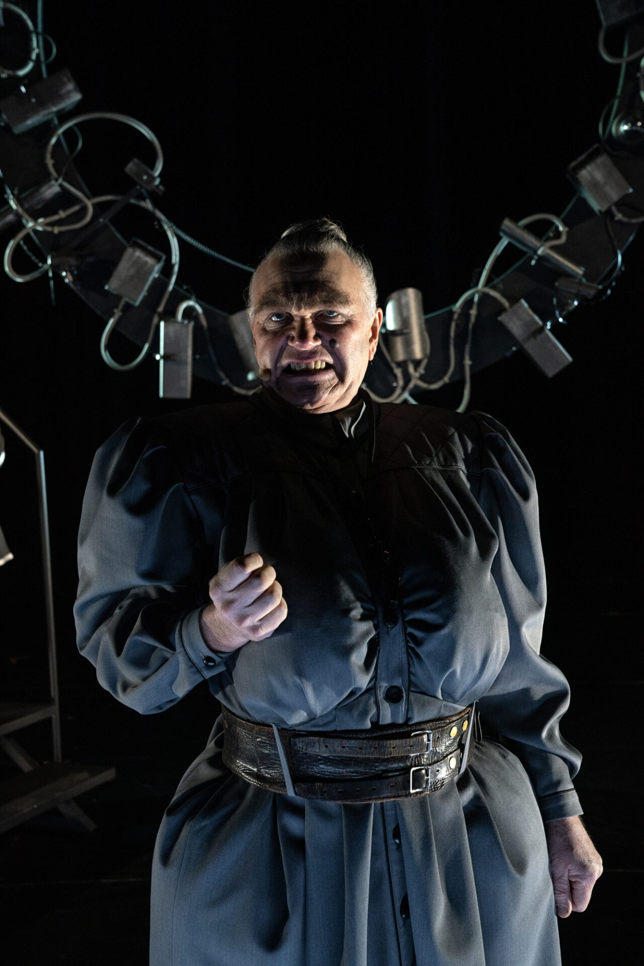 En meget ondskapsfull kvinne står med knyttet hånd