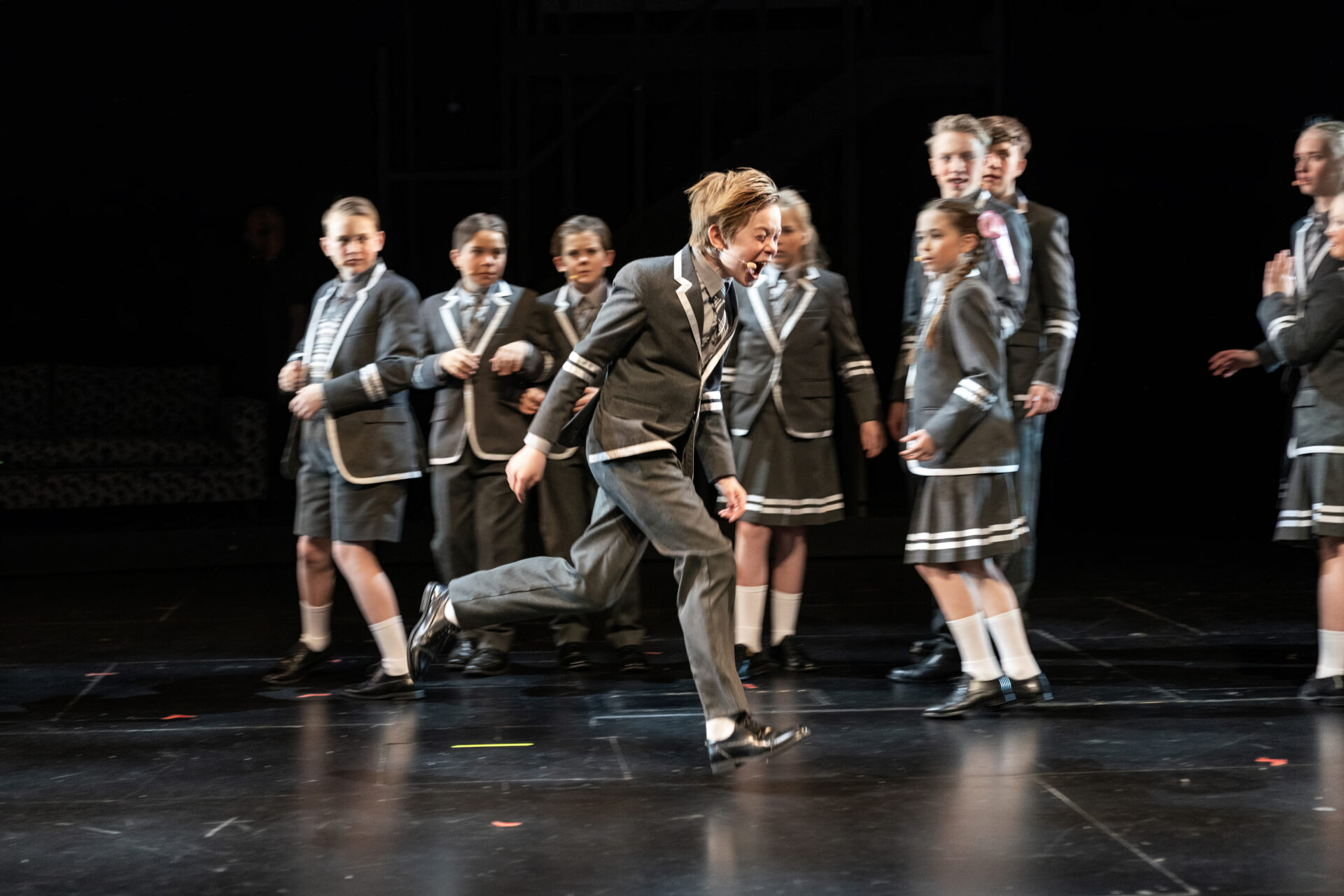 En liten gutt springer gråtende forbi sine klassekamerater