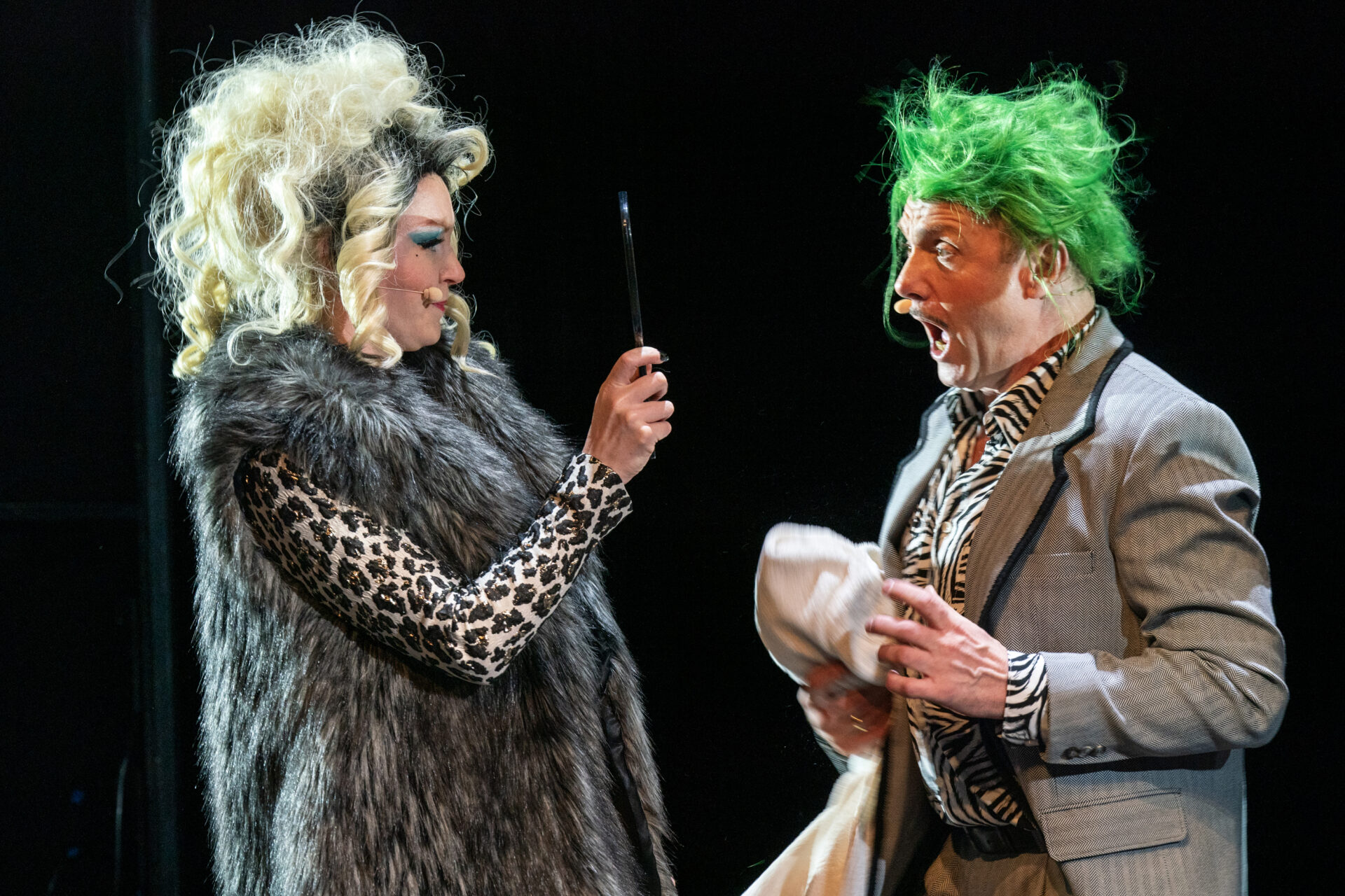 En kvinne holder opp et speil mot sin mann som er sjokkert over å se at han har grønt hår