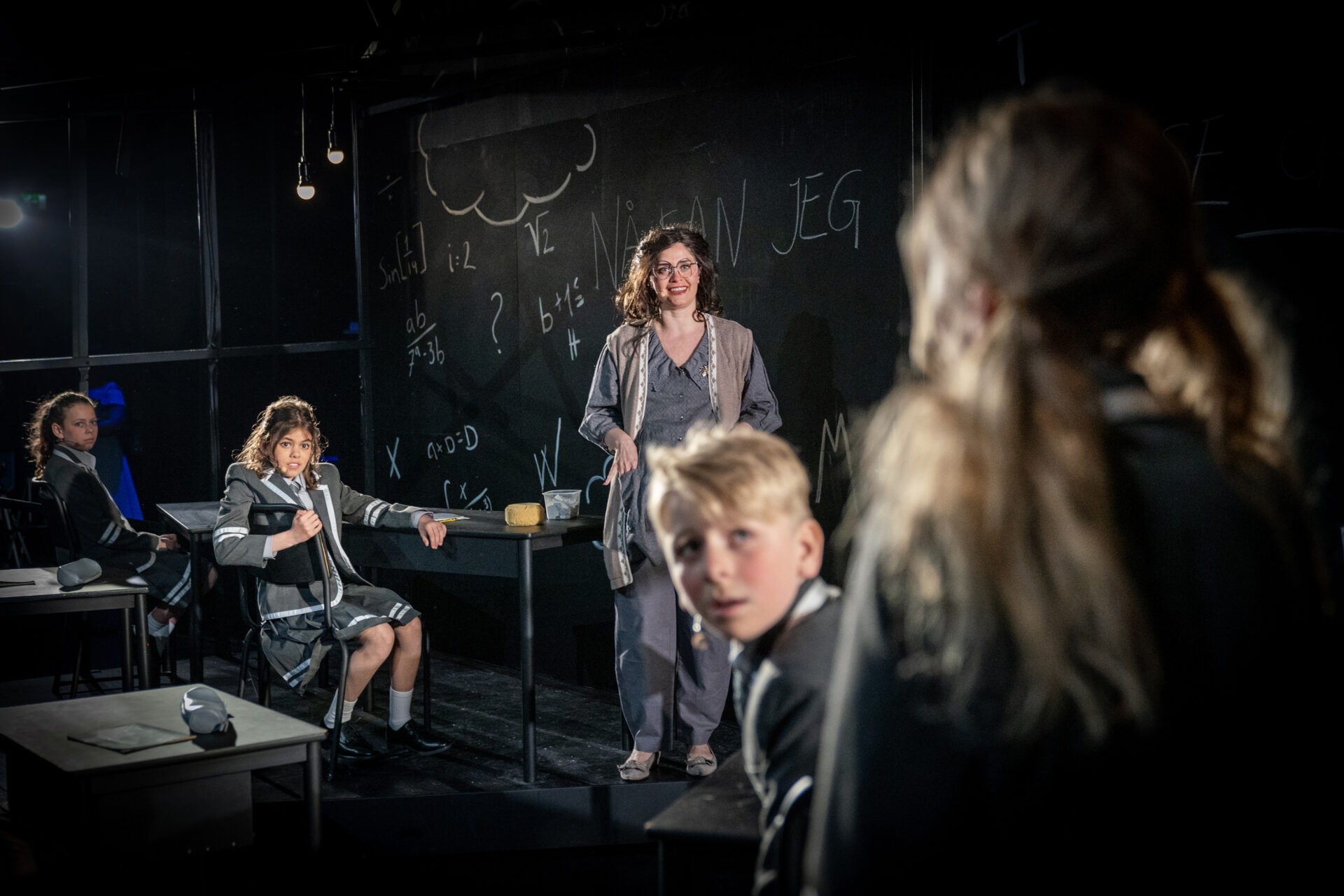 En lærer ser vennlig på en elev i klasserommet