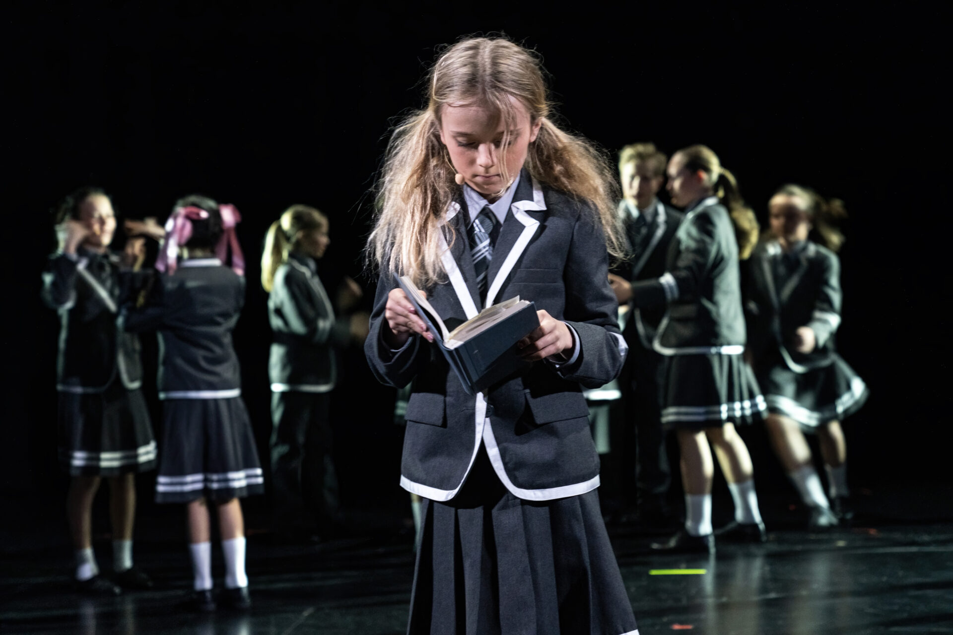 En liten jente leser i en bok