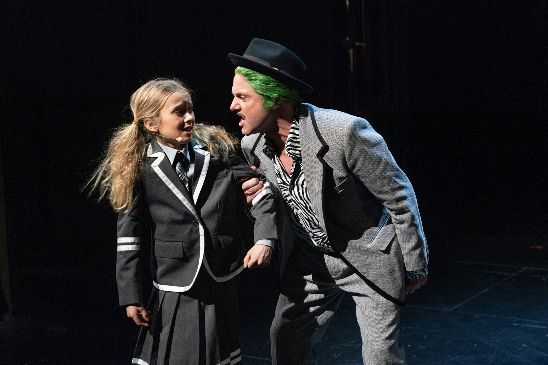 En far med grønt hår holder sin lille datter i armen og skriker til henne