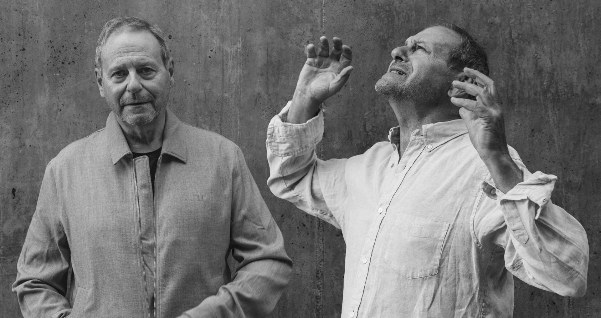 En mann ser mot oss og en annen man har hendene i været og fortviler