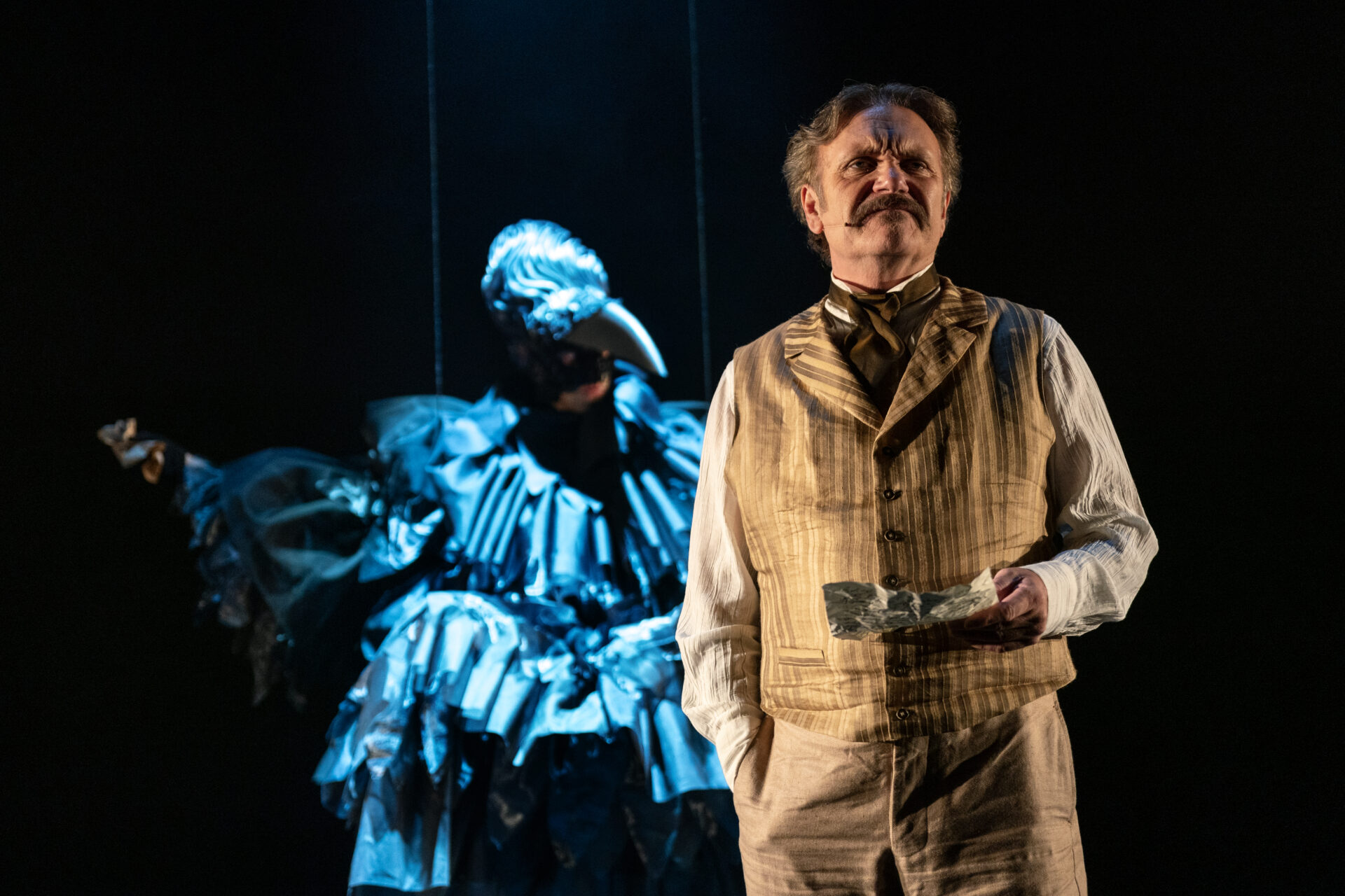 En mann med bart, med et brev i hånden og en ravn i bakgrunnen