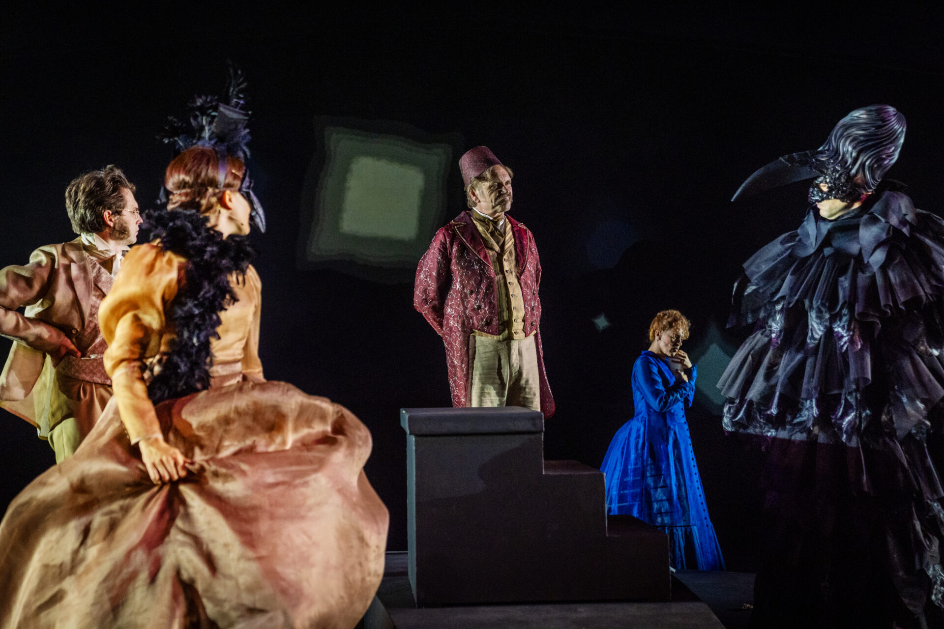 Festkledde skuespillere på scenen som ser mot hverandre