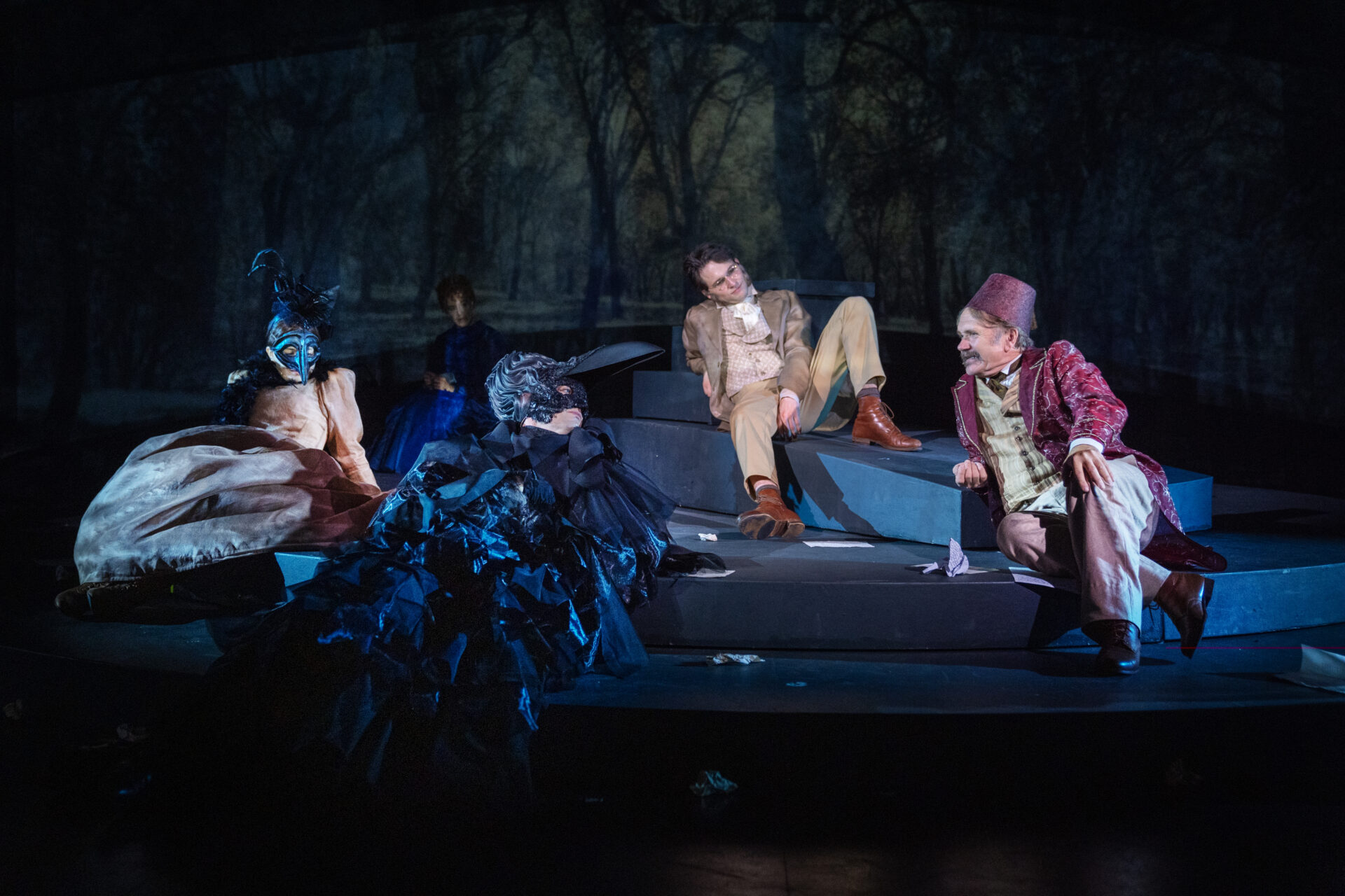 Mannlige skuespillere i et stykke, sitter og prater sammen på scenen