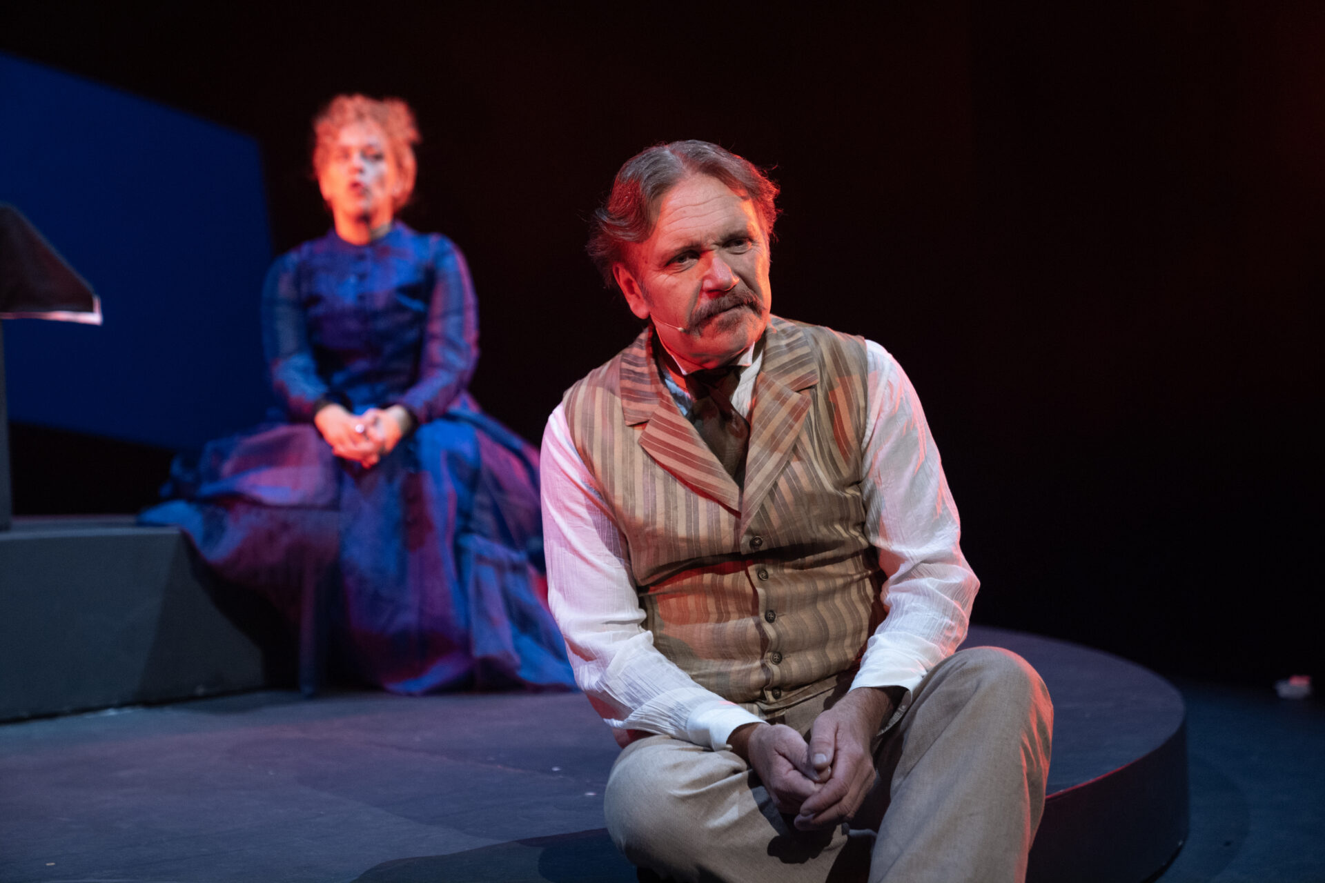 En mann sitter foran en kvinne på scenen