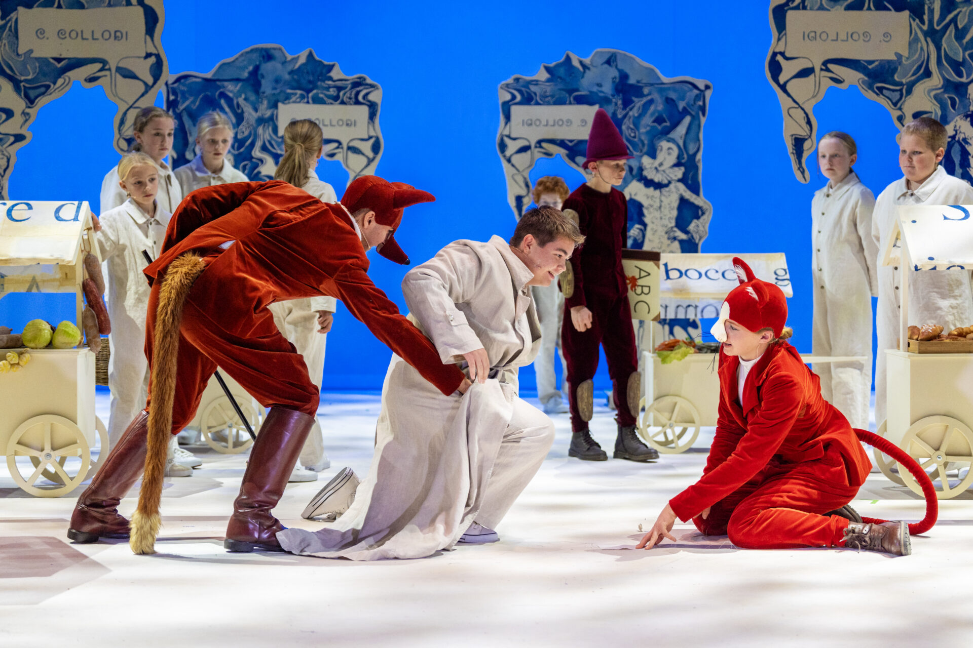 En rev og en katt prøver å stjele fra en intetanende mann