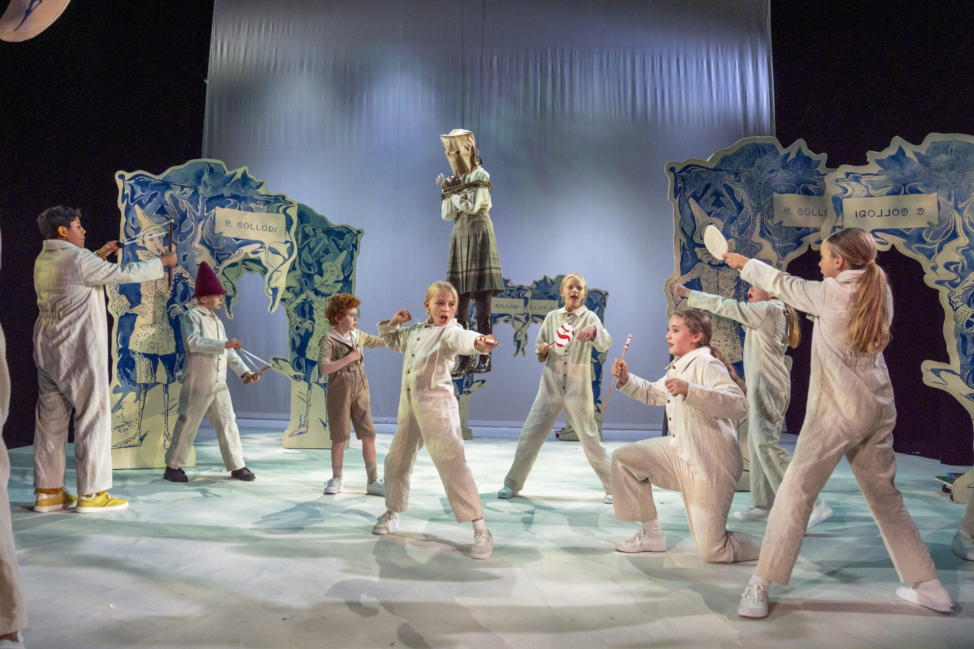 Mange barn står med sprettert og skyter på læreren