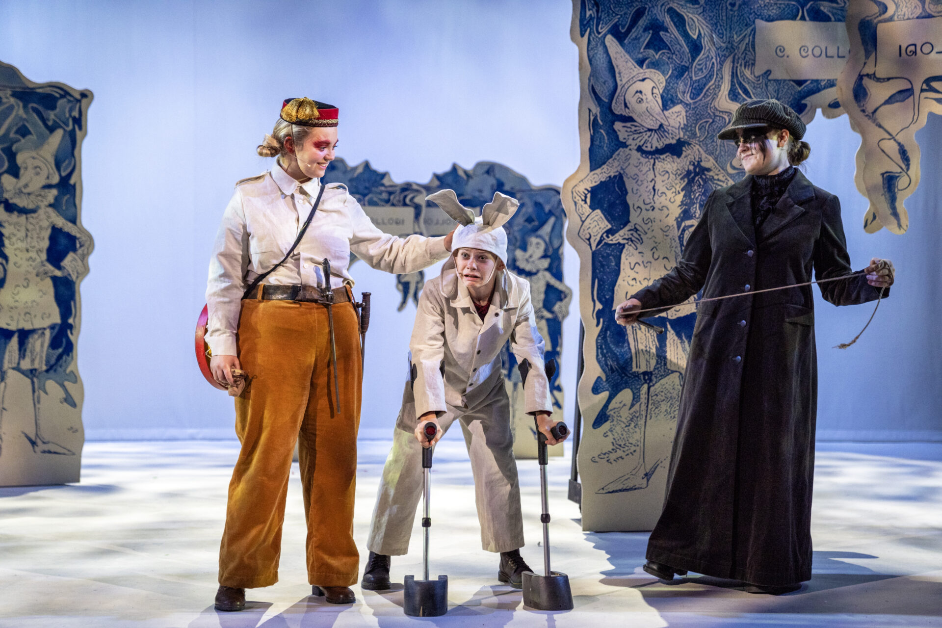 Trommeslageren og kusken forklarer hva de skal gjøre med en livredd Pinocchio.