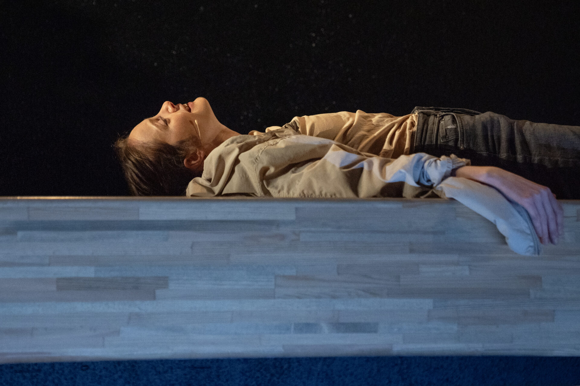 En skuespiller som ligger på ryggen på scenen, og titter opp - fra stykket Eg er vinden