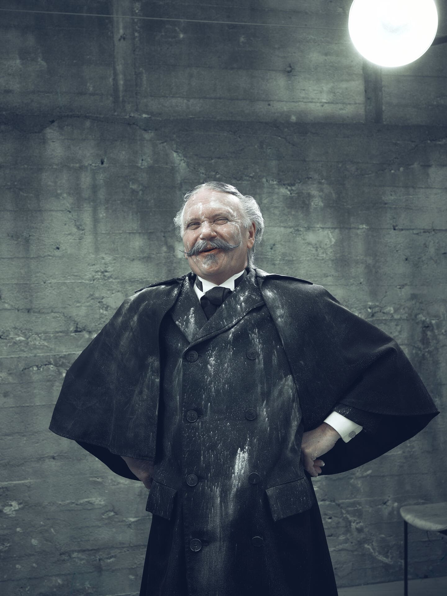 En smilende mann i gammeldagse klær, dekket i hvitt kritt.