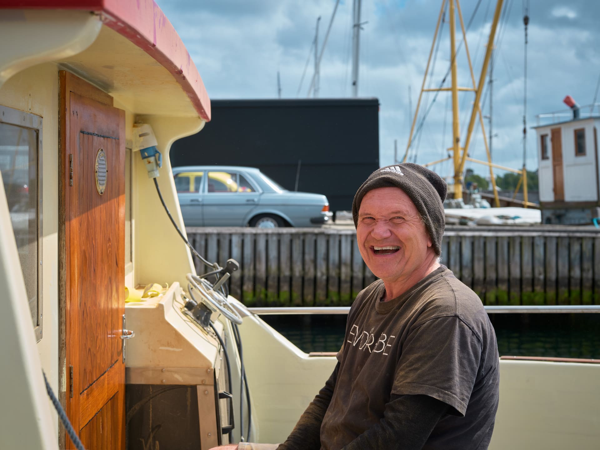 Mann som ler sittende i båt.