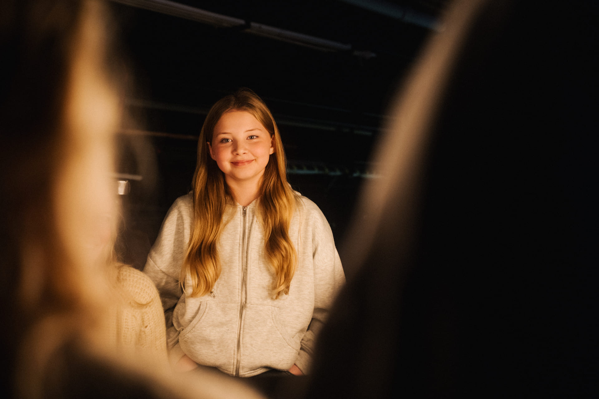 Smilende jente ser inn i kamera.