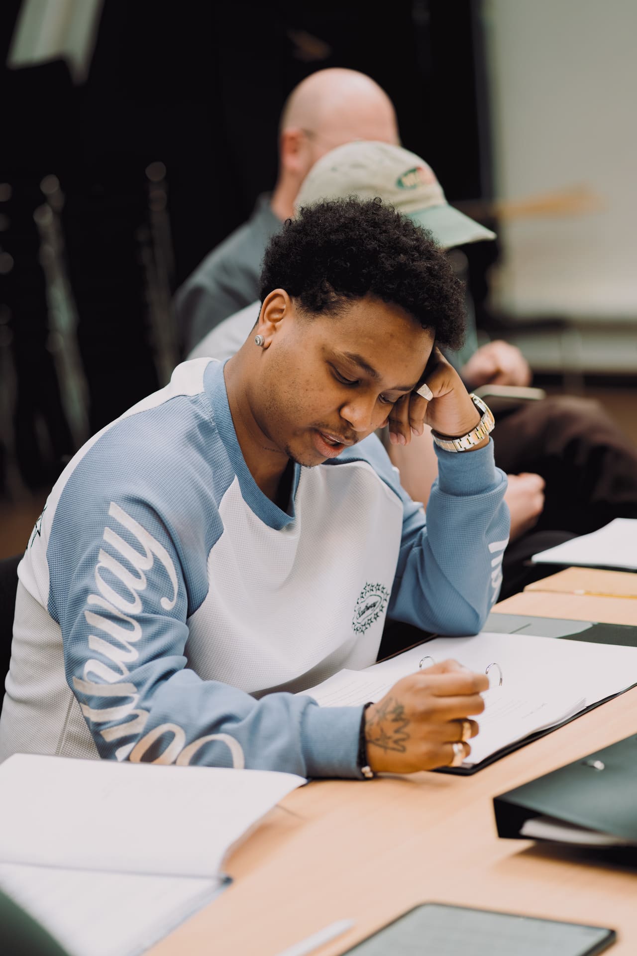 Skuespiller Kaleb Isaac sitter ved et bord og studerer manus