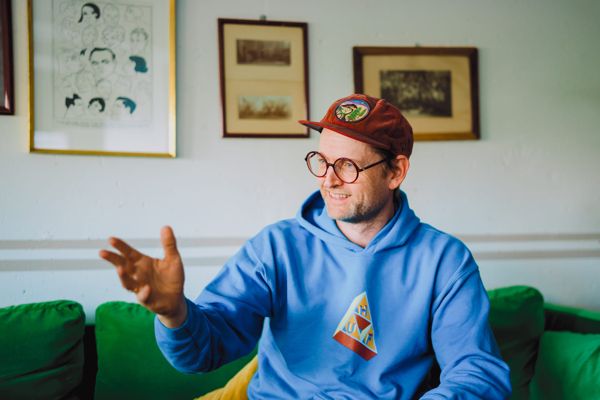 Regissør Nils Petter Mørland sittende på en grønn sofa.