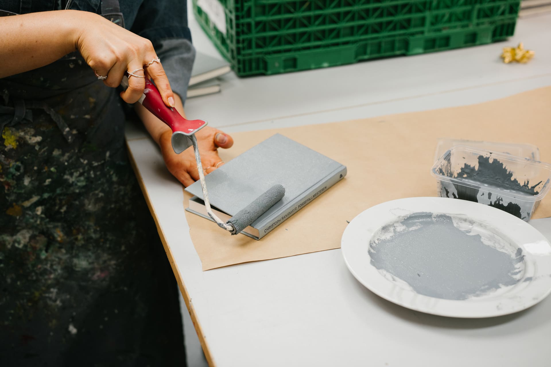 Nærbilde av en malerkost og en gråmalt bok.