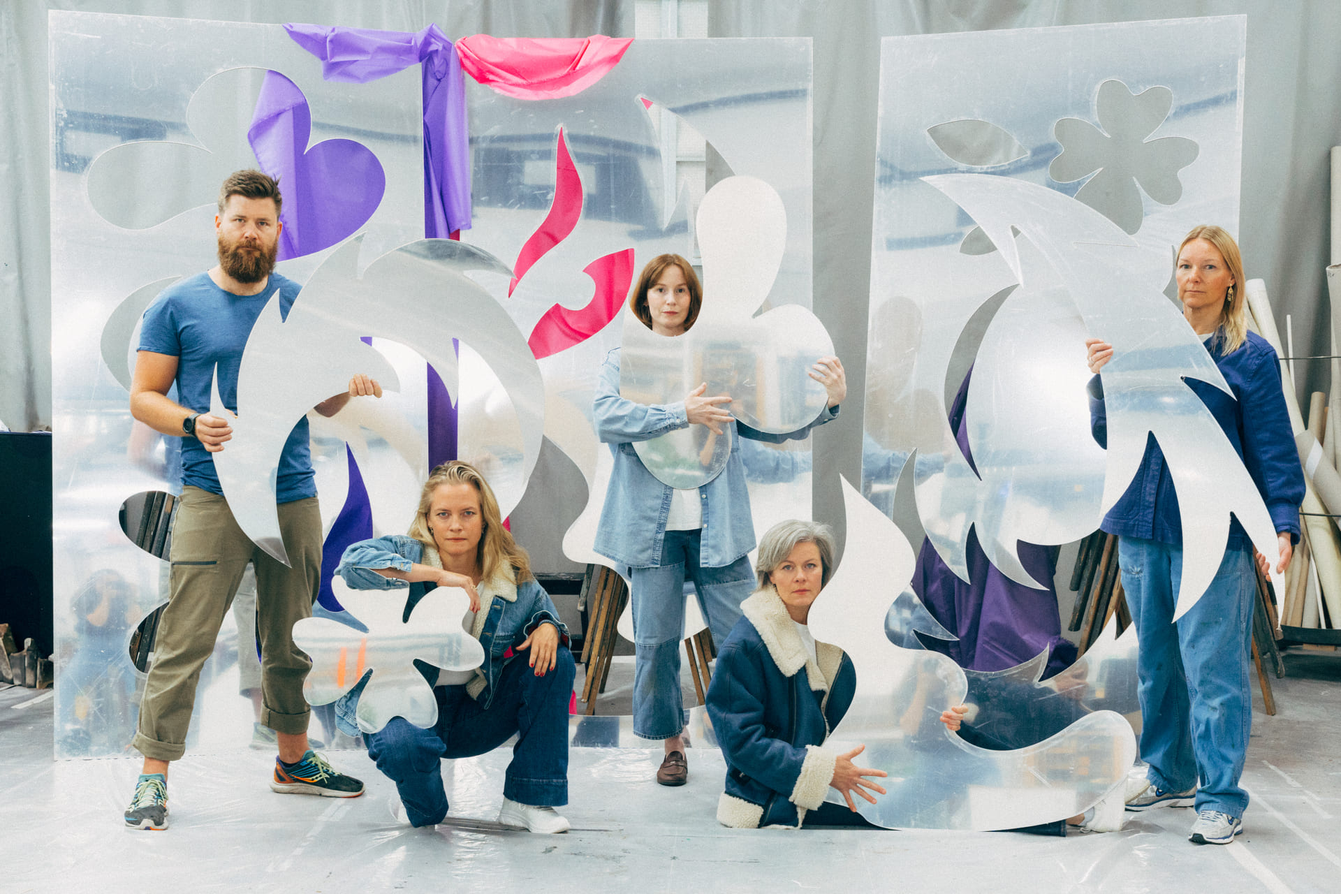 Medvirkende i stykket Wo(olf Women står og sitter blant abstrakte kulisser.