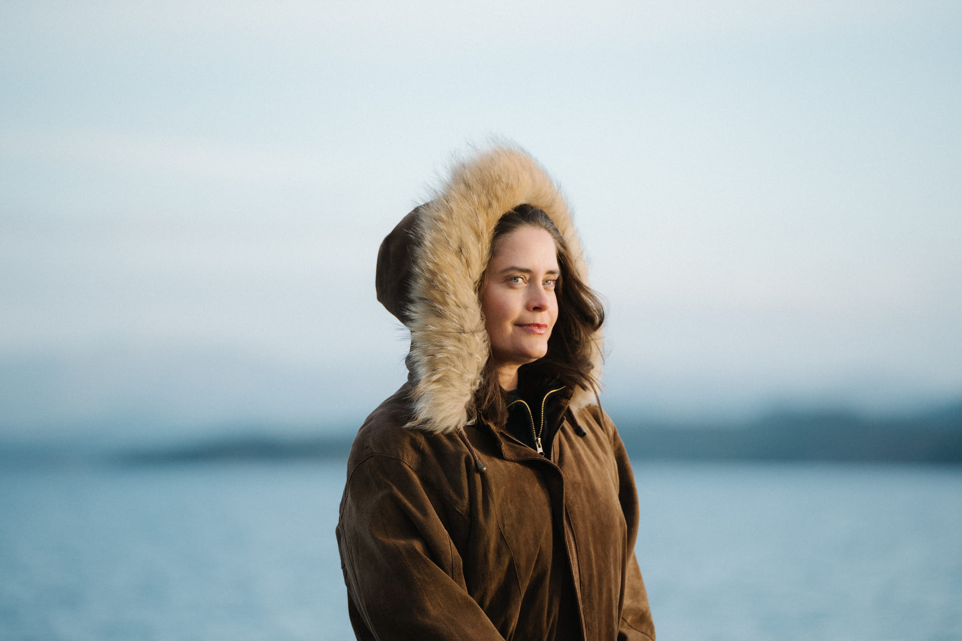 Kvinne i parka står ved et hav.