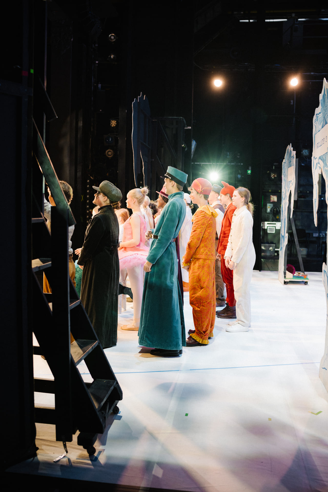 Skuespillere på scenen under en forestilling, sett fra siden.