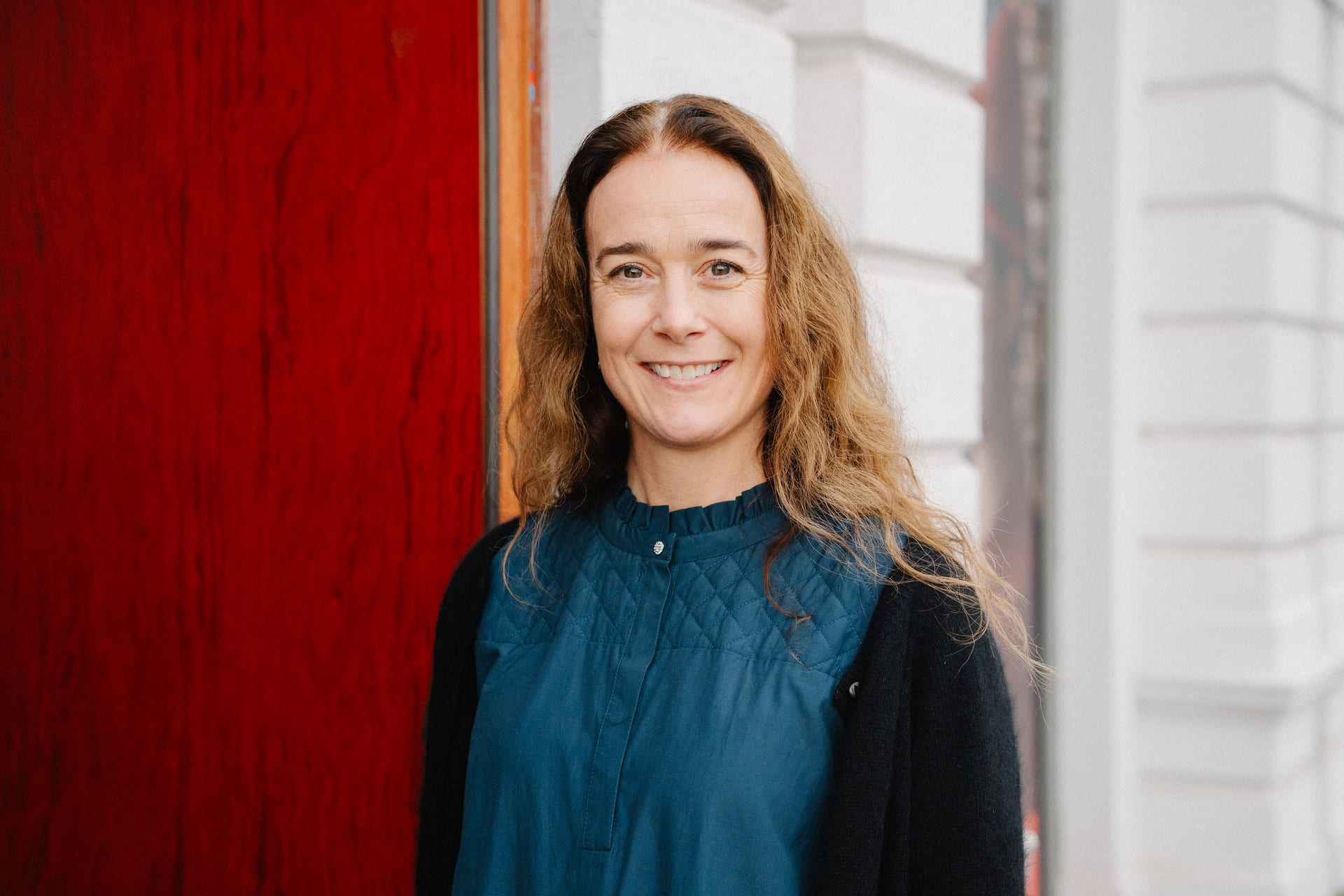 En smilende kvinne ser inn i kamera.